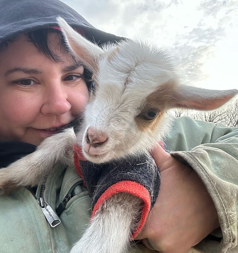 Woman holding baby goat