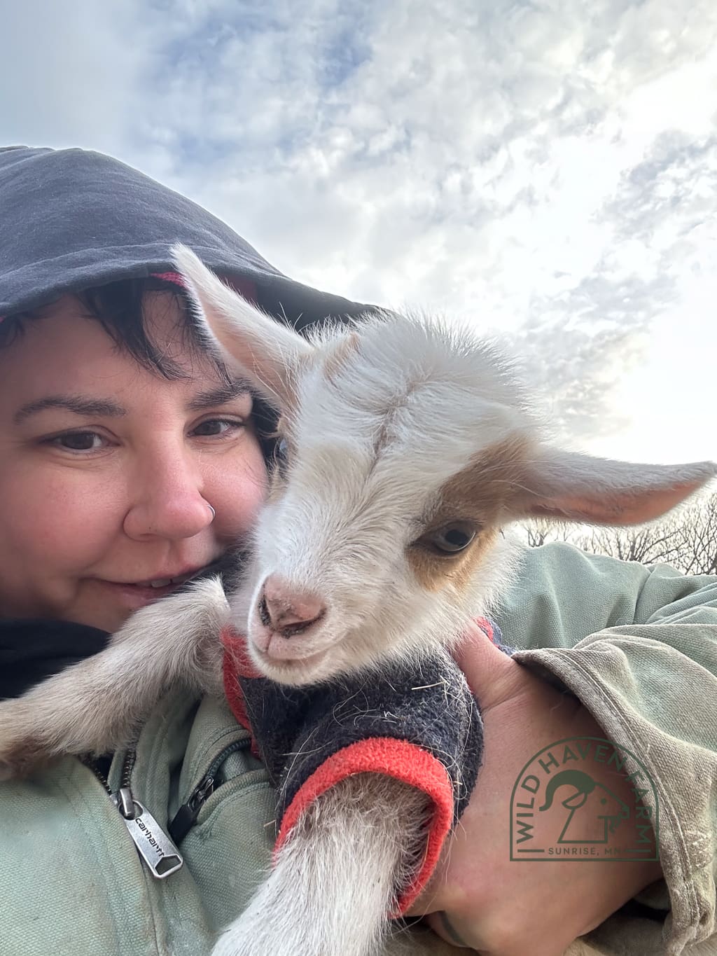 Mandi Garth 2024-03-18 Woman in winter coat holding goat kid